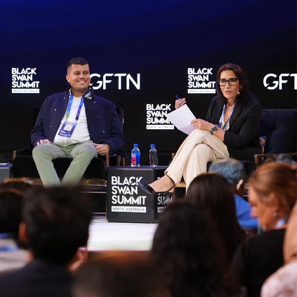 Two speakers on stage at a Black Swan Summit, in front of the audience