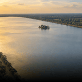 An Angkor reservoir at sunset, with a small island temple in the middle