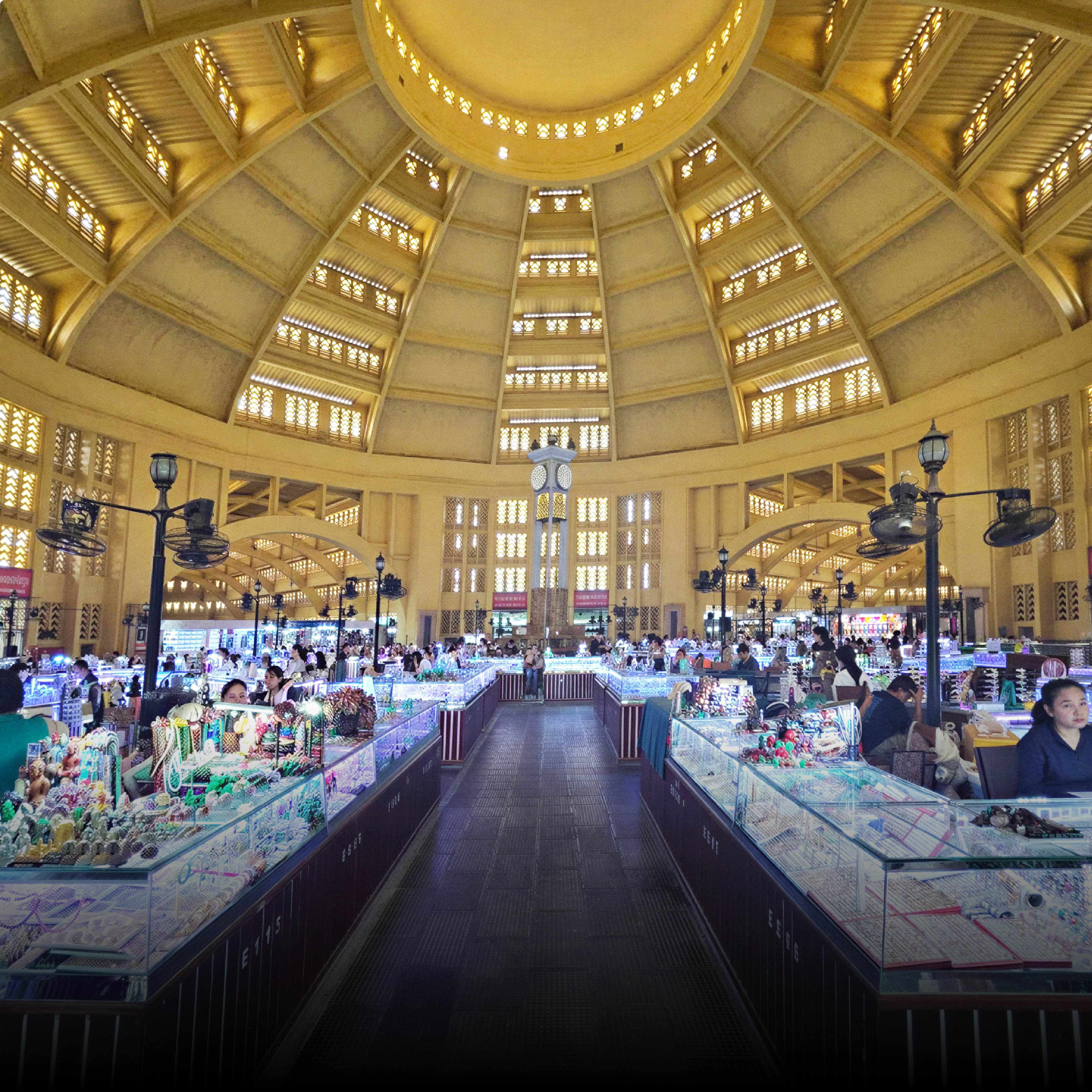 Stalls under the yellow dome of a Phnom Penh market hall